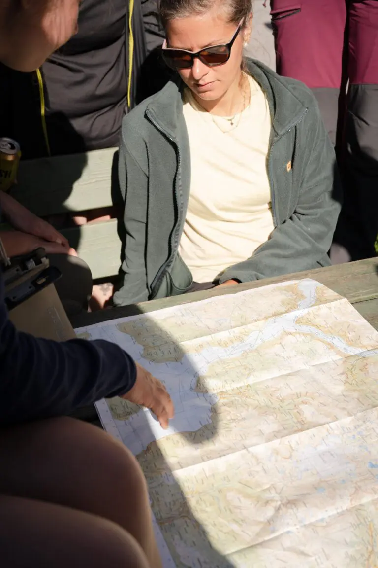 Menschen bei der Einweisung zu einer Kajaktour, die auf eine Karte schauen